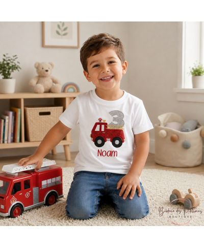 Enfant de 3 ans portant un t-shirt anniversaire pompier personnalisé avec prénom brodé en rouge