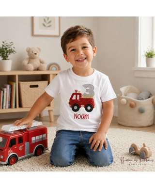 Enfant de 3 ans portant un t-shirt anniversaire pompier personnalisé avec prénom brodé en rouge